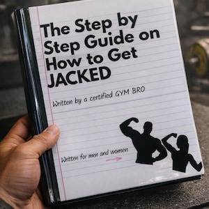 May include: A white notebook titled "The Step by Step Guide on How to Get JACKED" held by a person. The cover includes text, a silhouette of a muscular person, and the words "Written for men and women."