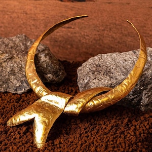 Może przedstawiać: Zestaw trzech ceramicznych kubków z nakrapianym, matowym wykończeniem. Kubki są w odcieniach kremu, jasnoszarym i ciemnoszarym. Każdy kubek ma prosty, minimalistyczny design, idealny do kawy lub herbaty.