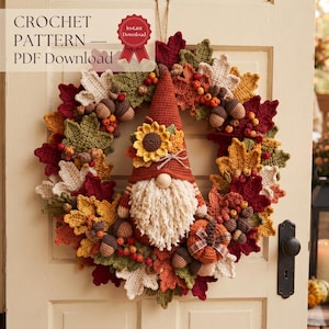 Può includere: Una ghirlanda all'uncinetto con foglie dai colori autunnali, ghiande, bacche e una figura centrale di gnomo con un girasole sul cappello. Il testo CROCHET PATTERN — PDF Download è visibile in alto a sinistra con un nastro Instant Download.