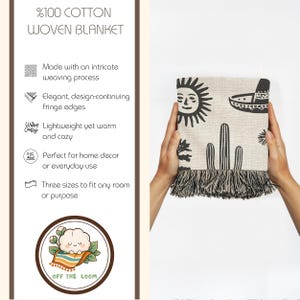 May include: A woven cotton blanket with a black and beige design featuring a sun, cactus, and sombrero. The blanket has fringe edges and is held by two hands. The blanket is made of 100% cotton.