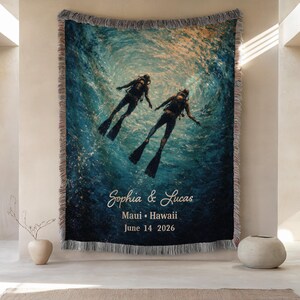 May include: Woven throw blanket featuring a vibrant underwater scene with two scuba divers. The blanket has a fringed edge and includes the names "Sophia & Lucas", location "Maui &bull; Hawaii", and date "June 14 2026" in white script.