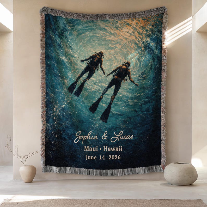 May include: Woven throw blanket featuring a vibrant underwater scene with two scuba divers. The blanket has a fringed edge and includes the names "Sophia & Lucas", location "Maui &bull; Hawaii", and date "June 14 2026" in white script.