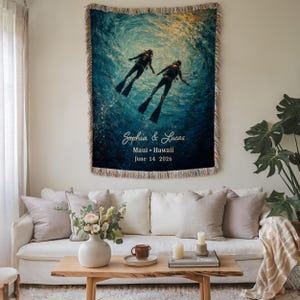 May include: Woven tapestry featuring a vibrant underwater scene with two divers. The image is predominantly blue and depicts a swirling water effect. Text at the bottom reads "Sophia & Lucas, Maui &bull; Hawaii, June 14 2026."
