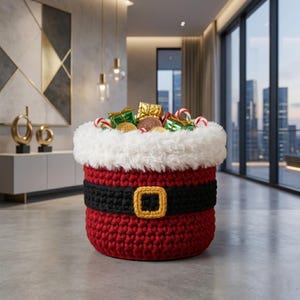 May include: A red crocheted basket resembling Santa's suit, with a black belt and gold buckle. The basket is filled with wrapped gifts, candy canes, and gold coins, perfect for holiday decor.