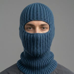 May include: A solid blue balaclava crafted with a vertical ribbed knit pattern. The headgear features a single large oval opening for the eyes, covering the head, neck, and face while maintaining a consistent texture throughout the entire garment.