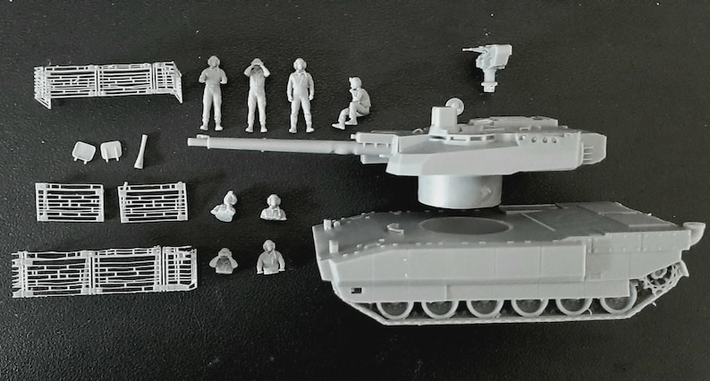Op de afbeelding: Een grijze plastic modeltankset bestaande uit een hoofdromp, een koepel met een lange loop en een apart machinegeweeronderdeel. De set bevat diverse kleine grijze plastic figuren van bemanningsleden in verschillende houdingen en rasterpanelen.