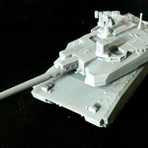Pode incluir: Um modelo em escala de tanque de cor cinza-claro sem pintura, apresentando um canh&atilde;o principal longo, uma torre girat&oacute;ria com uma metralhadora montada e blindagem detalhada. O ve&iacute;culo militar em miniatura &eacute; feito de resina com bordas.