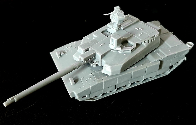 Pode incluir: Um modelo em escala de um tanque de batalha principal em pl&aacute;stico cinza, apresentando um canh&atilde;o longo, uma torre girat&oacute;ria e uma esta&ccedil;&atilde;o de metralhadora montada no topo. O corpo do tanque exibe blindagem detalhada, saias laterais e esteiras.