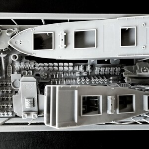 Peut inclure: Un cadre de kit de mod&eacute;lisme en plastique gris contenant deux coques de navires non peintes et divers petits composants. La grappe comprend de multiples pi&egrave;ces miniatures, dont des petites chaises, des &eacute;l&eacute;ments structurels et des accessoires de pont.