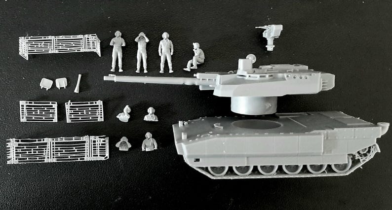 Pode incluir: Um kit de modelo de tanque em pl&aacute;stico cinzento com um casco principal, uma torre com um canh&atilde;o longo e uma metralhadora separada. O conjunto inclui v&aacute;rias pequenas figuras de soldados por pintar e pain&eacute;is de grelha retangulares.