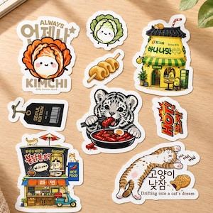 Peut inclure: Une collection d'autocollants découpés présentant des illustrations sur le thème coréen, notamment un chou souriant, une brique de lait à la banane, un tigre mangeant des gâteaux de riz épicés, un stand de ramen, un chat endormi et du texte.