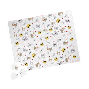 Pode incluir: Um quebra-cabeça retangular com um padrão repetitivo de rostos de gatos em desenho animado, espinhas de peixe e pequenos corações vermelhos sobre um fundo branco. O quebra-cabeça está parcialmente montado com peças soltas no canto inferior esquerdo.
