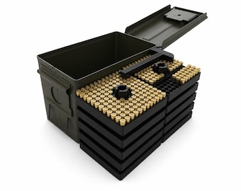 May include: An olive drab metal ammunition box with an open lid, containing multiple stacked black plastic trays filled with rows of brass-cased cartridges. The cartridges are arranged in organized grids with central black circular handles.