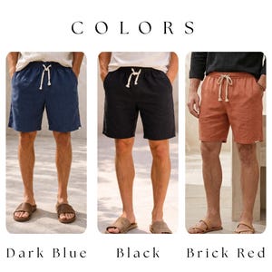 May include: Three pairs of linen shorts in dark blue, black, and brick red. Each pair has a drawstring waist and pockets. The image includes the word "COLORS" at the top and the color names below each pair of shorts.