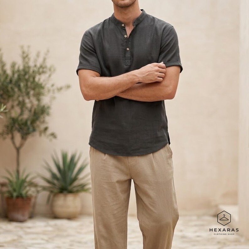 May include: A dark grey short-sleeved shirt with a mandarin collar and three buttons, worn with tan linen trousers. The shirt and trousers are made of a lightweight fabric. The image includes the text "HEXARAS CLOTHING SHOP".