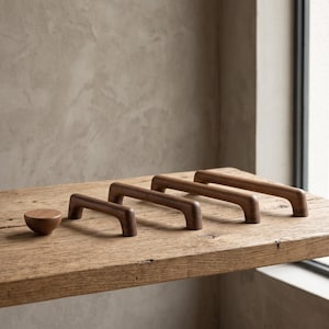 May include: A set of three dark brown wooden cabinet handles with a smooth, rounded arch design and one matching circular wooden knob, all featuring a natural wood grain finish and a consistent, clean, and simple structural form.