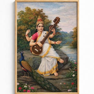 May include: Framed artwork depicting a woman playing a stringed instrument, seated on a rock near a body of water. A peacock stands nearby. The woman wears a white and gold sari, with a red and gold headdress. The background features trees and a blue sky.