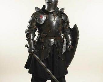 May include: Full suit of dark metal armor, including a helmet, shoulder guards, chest plate, and leg protection. The knight is holding a long sword and a shield. The armor has a red circular emblem on the chest.