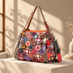 Puede incluir: Un bolso de mano multicolor con un patrón de rombos acolchados, adornado con numerosas pequeñas aplicaciones de flores de cuero superpuestas en varios tonos. El bolso incluye un asa superior, una correa de hombro desmontable y herrajes de metal plateado.