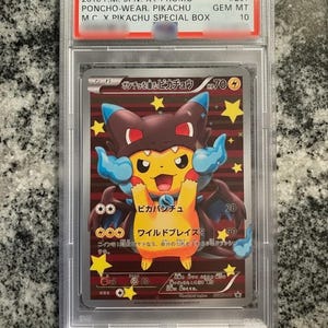 Puede incluir: Carta Pokémon graduada con Pikachu con poncho, en estuche protector. Texto japonés. De la serie 2016 XY Promo, específicamente el set Poncho-Wear Pikachu. Número #207, GEM MT 10.