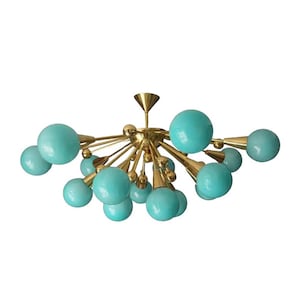 May include: A mid-century modern chandelier with a brass finish and turquoise globe-shaped lights. The fixture has multiple arms extending from a central point, each ending in a turquoise sphere. The design is reminiscent of atomic age aesthetics.