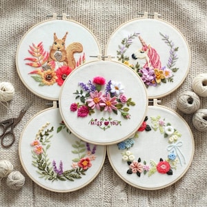 May include: Five embroidered hoops with floral and animal designs. One hoop features a squirrel with flowers, another a unicorn, and a third has the text "Miss You". The embroidery is in various colors, including pink, red, and green.