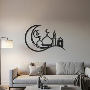 May include: Black metal wall art depicting a mosque silhouette with a crescent moon and star design. The artwork features a mosque with a dome, minaret, and arched windows. The wall art is mounted on a neutral-colored wall above a sofa.