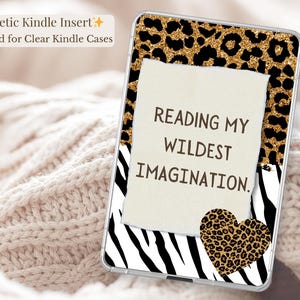 Op de afbeelding: Kindle-inzet met een helder hoesontwerp. De inzet heeft een luipaardprintrand en een zebraprintbasis. Een gescheurd papieren element toont de tekst "READING MY WILDEST IMAGINATION". Een hart met luipaardprint is ook inbegrepen.