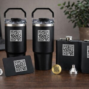 Könnte beinhalten: Schwarze isolierte Becher, Flachmänner und eine Visitenkarte mit einem QR-Code-Design. Die Becher haben Griffe und transparente Deckel. Eine kleine Goldmünze und eine Silbermünze mit QR-Codes sind ebenfalls vorhanden.