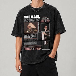 Peut inclure: Un t-shirt noir délavé à l'acide avec une impression graphique de Michael Jackson. Le design comprend le texte "MICHAEL JACKSON", "KING OF POP" et "NEW EP", ainsi que trois panneaux photographiques de l'artiste et un code-barres.