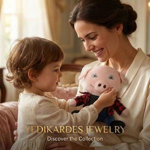 May include: A young child and an adult are seated on a plush, pink sofa, interacting with a stuffed pig toy. The pig has a pink body, blue pants, and a red and black plaid shirt. The text "YEDIKARDES JEWELRY Discover the Collection" is visible.