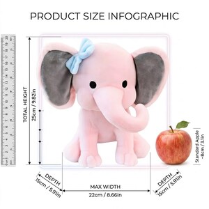 K&ouml;nnte beinhalten: Ein rosa Pl&uuml;schelefant-Spielzeug mit grauen Ohren und einer blauen Schleife. Das Spielzeug ist 25 cm hoch und 22 cm breit. Ein roter Apfel dient zum Gr&ouml;&szlig;envergleich.