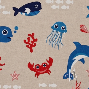 Puede incluir: Tela beige con un patrón repetido de criaturas marinas. El diseño incluye ballenas azules, delfines, medusas y peces, junto con coral rojo, cangrejos y estrellas de mar. Las ilustraciones son de estilo caricatura.