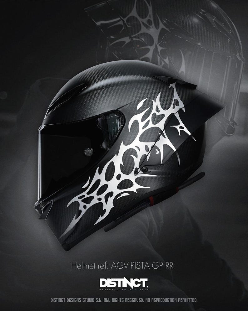 May include: A black motorcycle helmet with a carbon fiber weave pattern and a white tribal design on the side. The helmet has a dark visor and the text "DISTINCT" is visible.