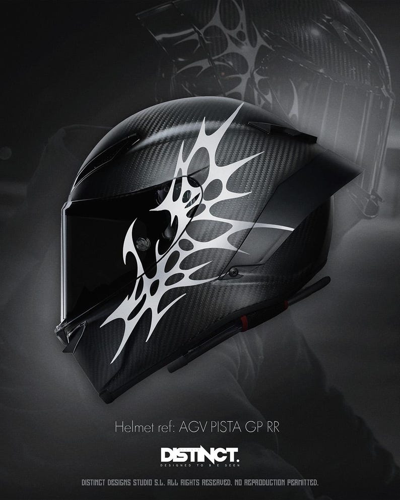 May include: A black motorcycle helmet with a carbon fiber weave pattern and a white tribal design. The helmet has a visor and the text "Helmet ref: AGV PISTA GP RR" and "DISTINCT." is visible.