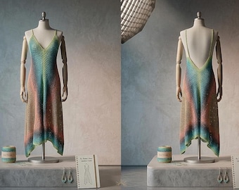 May include: A handmade, gradient crochet dress displayed on a mannequin. The dress transitions from green to blue, then to peach and tan. A matching ball of yarn, earrings, and a booklet are also present.