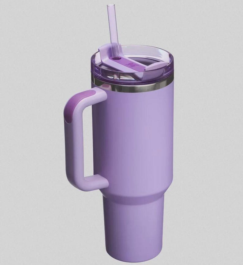 May include: A lavender insulated tumbler with a handle and a clear lid. The tumbler has a matching lavender handle and a clear straw. The lid has a sliding closure to prevent spills. The tumbler is designed to keep drinks cold or hot.