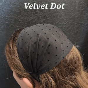 May include: A black head covering with a dotted pattern, worn on the head. The text "Velvet Dot" is displayed in white. The head covering is made of a sheer fabric and is secured with a thin band.