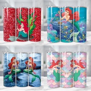 K&ouml;nnte beinhalten: Eine Auswahl von vier Edelstahlbechern mit Strohhalmen, die Meerjungfrau-Designs zeigen. Die Becher haben ein Fassungsverm&ouml;gen von etwa 590 ml. Die Designs umfassen roten Glitzer, Unterwasserszenen und Meerjungfrau-Schuppenmuster, alle mit Arielle, die Meerjungfrau.
