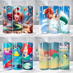 K&ouml;nnte beinhalten: Vier Edelstahlbecher mit verschiedenen Illustrationen von Arielle aus Arielle, die Meerjungfrau. Die Designs zeigen Arielle mit roten Haaren und einem gr&uuml;nen Schwanz, zusammen mit anderen Charakteren, vor Unterwasser- und Himmelshintergr&uuml;nden.