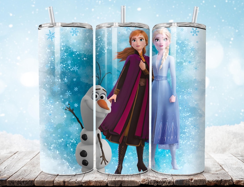 Puede incluir: Tres vasos de acero inoxidable con pajitas, cada uno con un personaje de la pel&iacute;cula animada Frozen. Los personajes son Anna, Elsa y Olaf, sobre un fondo de copos de nieve azules y blancos.
