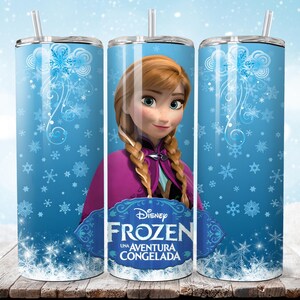 Puede incluir: Un vaso de acero inoxidable con el personaje de Disney Frozen, Anna. El vaso tiene un fondo azul claro con dise&ntilde;os de copos de nieve. Tambi&eacute;n se ve el logotipo de Disney Frozen y el texto "Una Aventura Congelada".