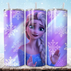 Puede incluir: Un vaso de acero inoxidable con una imagen de dibujos animados de Elsa de Frozen. El vaso tiene un fondo morado y azul con dise&ntilde;os de copos de nieve blancos. El personaje lleva un vestido azul y tiene el pelo rubio.