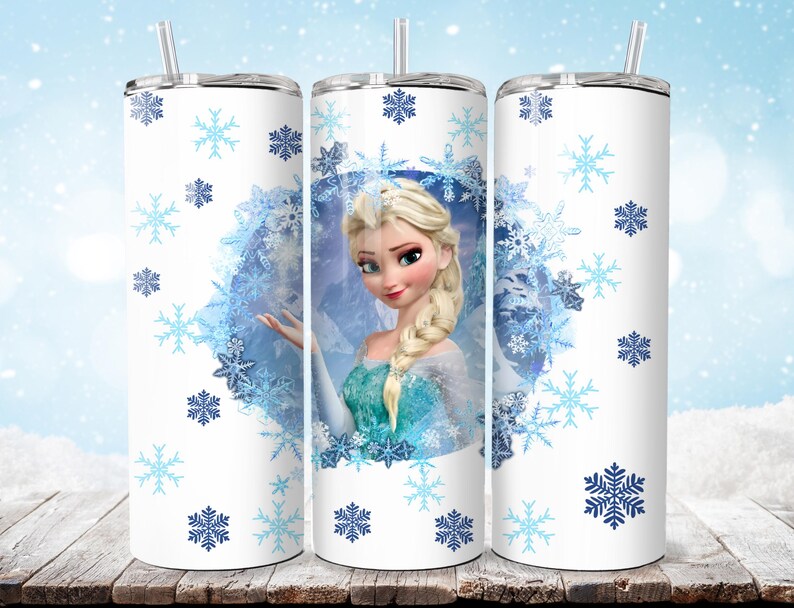 Puede incluir: Un vaso blanco con un dise&ntilde;o de Elsa de Frozen, rodeado de copos de nieve azules. El vaso tiene una tapa plateada y una pajita transparente. El dise&ntilde;o incluye un retrato de Elsa con un vestido azul y turquesa.