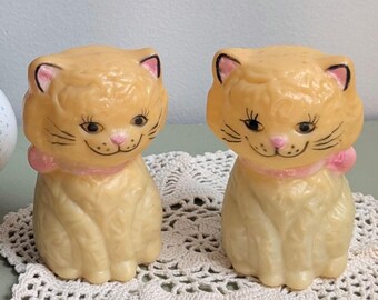 Saliera e pepiera vintage in plastica a forma di gatto con fiocchi rosa, stile retrò kitsch.