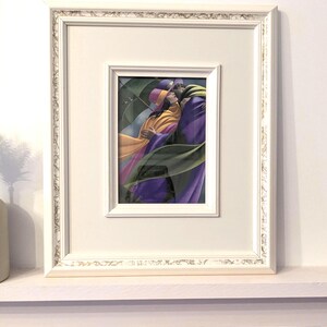 May include: Framed art print featuring a couple embracing, rendered in vibrant colors. The artwork depicts figures in flowing robes, with a palette of purple, yellow, and green. The print is set within a white frame with ornate detailing, adding a touch of elegance.