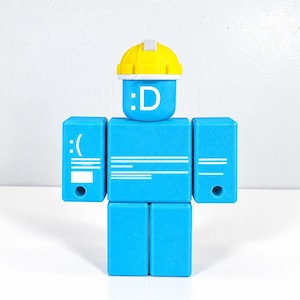 May include: A blue block-shaped figure with a yellow hard hat. The head features a white :D emoticon. The torso and arms display white text and graphics resembling a computer error screen, including a :( emoticon and horizontal lines.