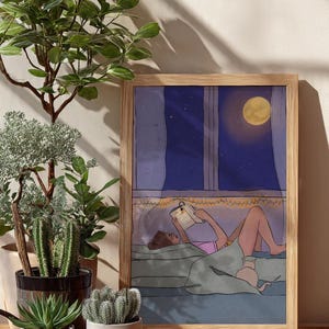 Pode incluir: Ilustração emoldurada de uma pessoa lendo na cama à noite, iluminada pela lua cheia e luzes de corda. A obra de arte está em uma moldura de madeira, com várias plantas em vasos em primeiro plano, criando uma cena relaxante.