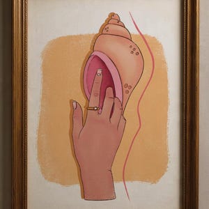 Pode incluir: Impressão artística emoldurada com uma mão com um anel de ouro, interagindo com uma grande concha. A obra de arte usa uma paleta de cores quentes com tons de rosa, pêssego e dourado. A concha tem um interior rosa e um exterior texturizado.