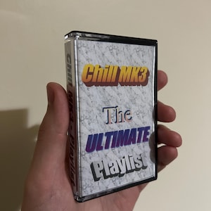 Può includere: Una musicassetta trasparente con un'etichetta a motivo marmorizzato. L'etichetta presenta il testo "Chill MK3" in giallo e arancione e "The ULTIMATE Playlist" in blu e bianco. La musicassetta è tenuta in mano.